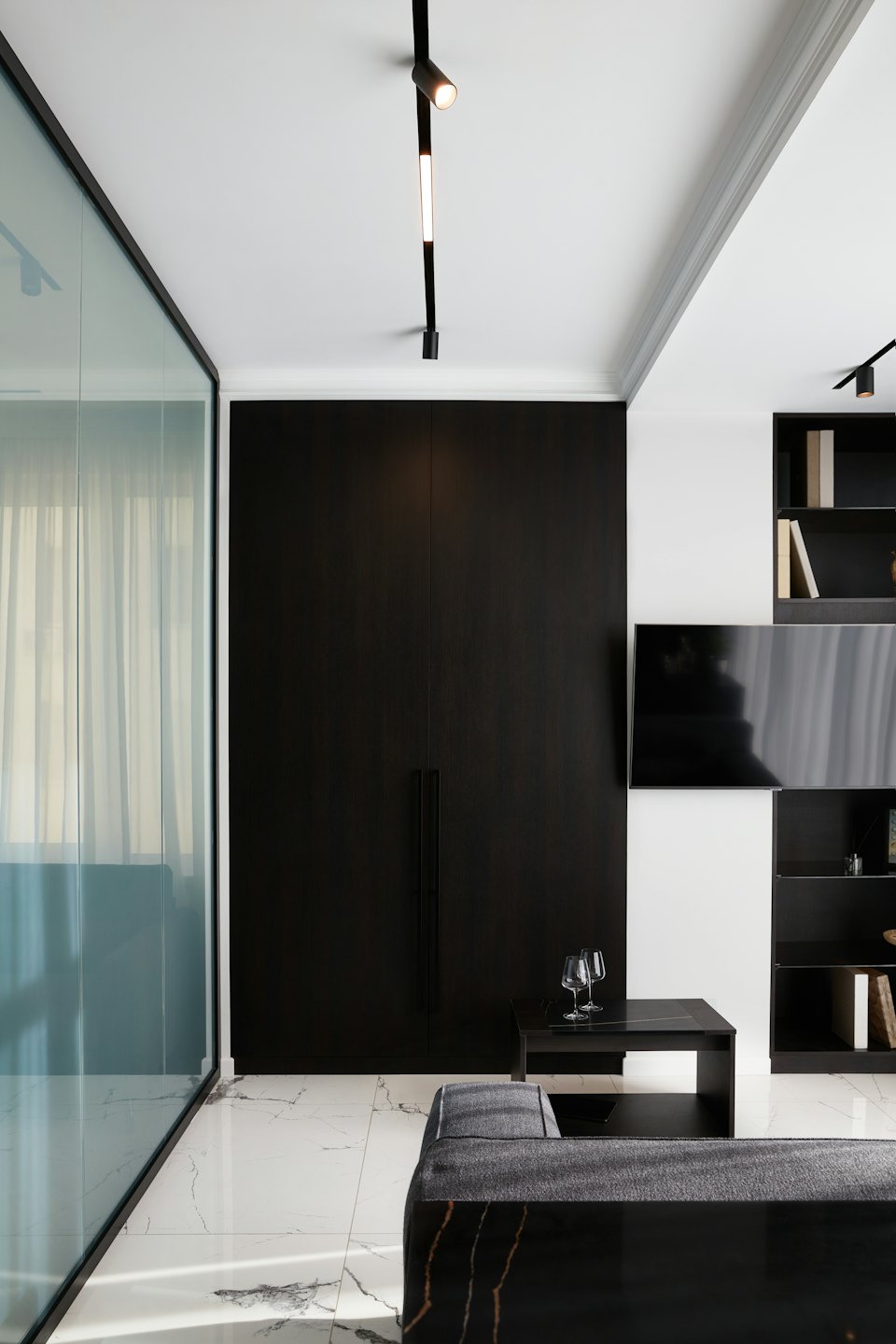 Modernes Wohnzimmer mit dunklem Holzschrank und Marmorboden.